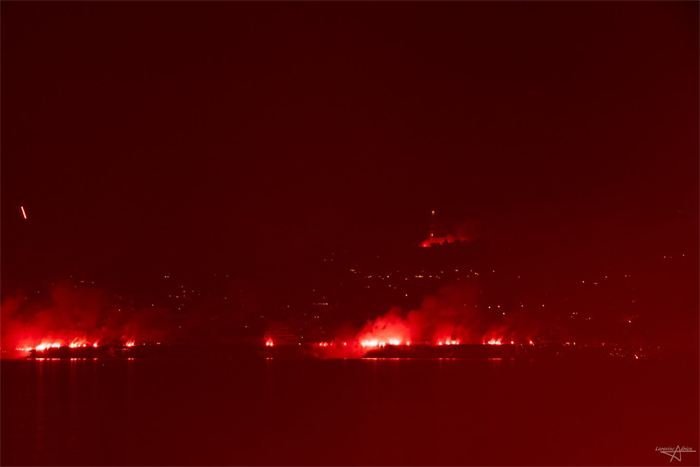 Lueurs rouges de fumigènes dans la nuit