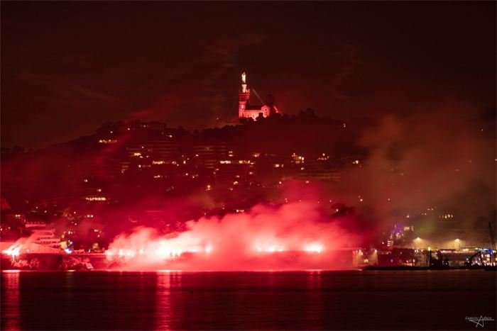 Fumigènes rouges illuminant une colline dans la nuit